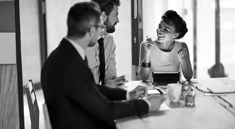 Advisers in discussion with a client across a meeting table